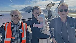 Die Piloten Dr. Michael Offermann (links) und Dr. Gerrit Arlt (rechts) mit der kleinen Marie und ihrer Mama.