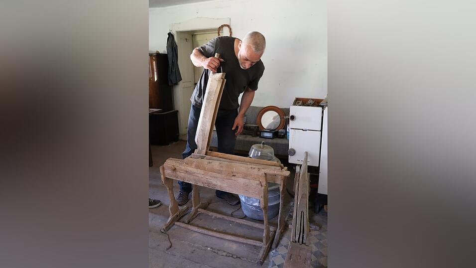 Ein Brechel bricht die holzigen Teile des Flachses.