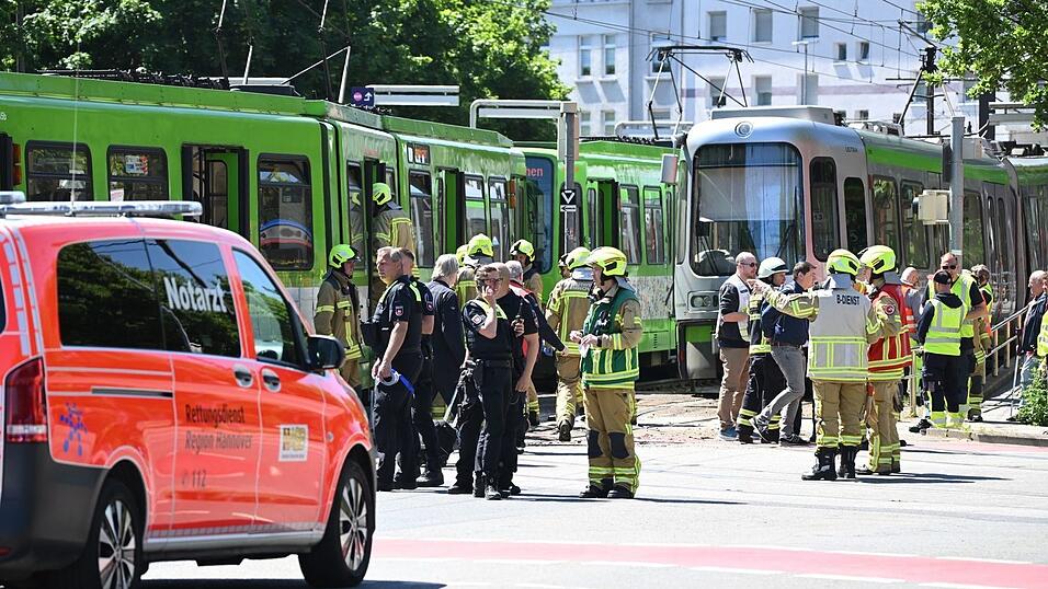 Einsatzkr&auml;fte von Polizei und Feuerwehr stehen nach einem Unfall neben zwei Stadtbahnen.