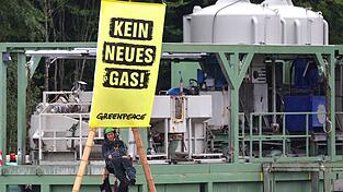 Die Umweltorganisation Greenpeace protestiert gegen die geplante Gasbohrung in Reichling. Ein Umweltschützer hängt an einem Bambusgerüst.