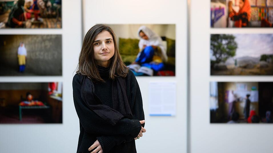 Fotojournalistin Elise Blanchard steht vor den pr&auml;mierten Bildern.