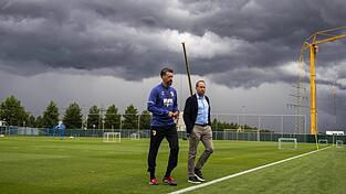 Geschäftsführer Michael Ströll (r., hier mit Trainer Sandro Wagner) wollte das „Graue Maus“-Image des Vereins loswerden - nun aber ziehen graue Gewitterwolken über Augsburg auf.