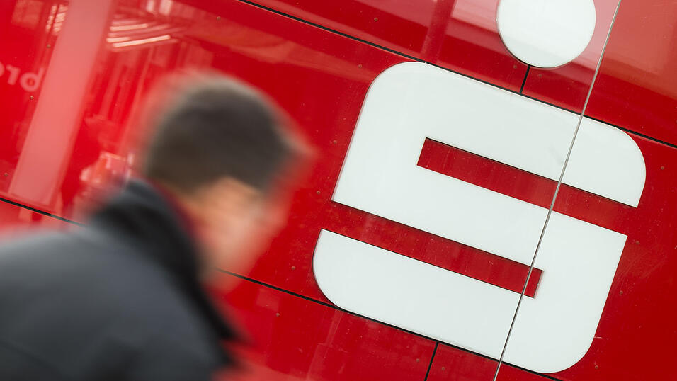Passanten laufen an einer Filiale der Sparkasse vorbei. (Symbolbild) Passanten laufen an einer Filiale der Sparkasse vorbei. (Symbolbild)