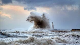 Hohe Wellen schlagen über einen Wellenbrecher vor dem Leuchtturm von Seaham in der Grafschaft County Durham. 'Wellenbrecher' ist das Wort des Jahres 2021, wie die Gesellschaft für deutsche Sprache bekanntgab.