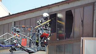 Ein Feuerwehrmann entnimmt mit einem Einreißhaken ein Stück der Dachisolierung. Ein Feuerwehrmann entnimmt mit einem Einreißhaken ein Stück der Dachisolierung.