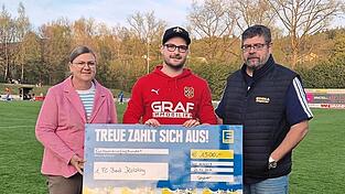 Vorsitzender Sebastian Kuchler (Mitte) nimmt den Scheck aus den H&auml;nden der Marktinhaber Martina und Stefan Segerer entgegen.