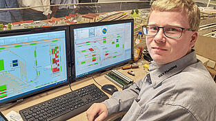 Simon Fischer vor dem elektronischen Stellwerk der Miniaturanlage.