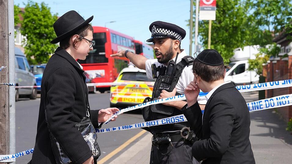 Ein Polizeibeamter spricht mit zwei j&uuml;dischen Buben nahe dem Tatort in Golders Green im Nordwesten Londons, nachdem zwei Menschen niedergestochen wurden. In einem stark j&uuml;disch gepr&auml;gten Viertel soll ein Angreifer Berichten zufolge zwei j&uuml;dische Menschen verletzt haben. Erst vor wenigen Wochen kam es dort zu einem antisemitischen Brandanschlag.