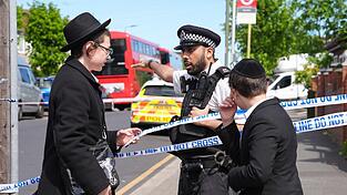 Ein Polizeibeamter spricht mit zwei j&uuml;dischen Buben nahe dem Tatort in Golders Green im Nordwesten Londons, nachdem zwei Menschen niedergestochen wurden. In einem stark j&uuml;disch gepr&auml;gten Viertel soll ein Angreifer Berichten zufolge zwei j&uuml;dische Menschen verletzt haben. Erst vor wenigen Wochen kam es dort zu einem antisemitischen Brandanschlag.
