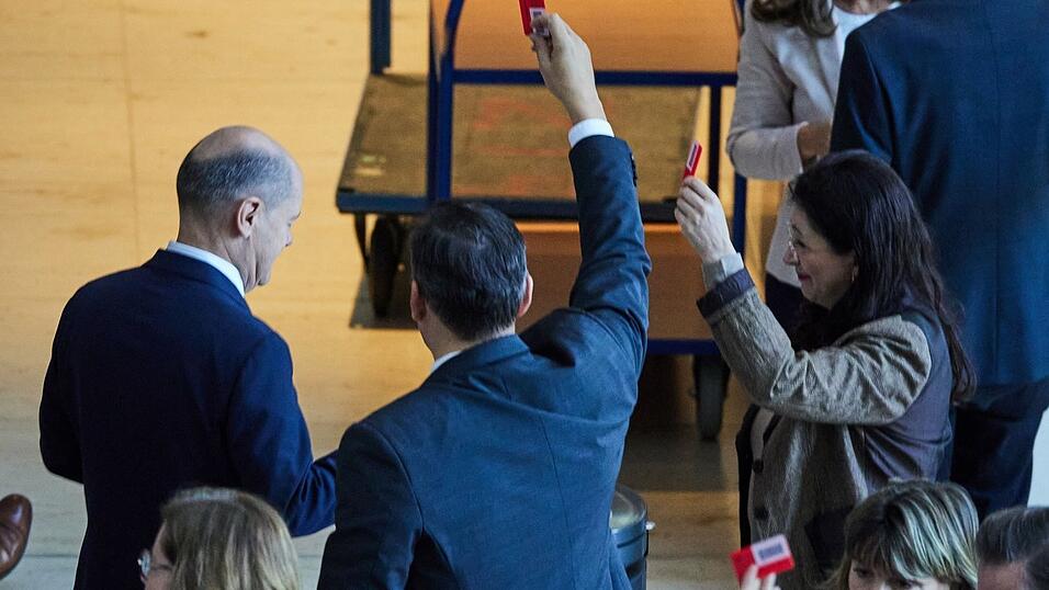 Bundeskanzler Olaf Scholz (l., SPD) gibt bei der 195. Sitzung des Deutschen Bundestages namentlich seine Stimme zum Sicherheitspaket ab. Die Abgeordneten befassten sich mit mehreren Vorlagen zur inneren Sicherheit.