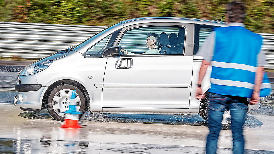 Eine Seniorin fährt mit ihrem Auto über eine Teststrecke.