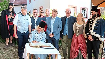 Im Beisein der Ehreng&auml;ste tr&auml;gt sich die Ministerin ins Goldene Buch ein.