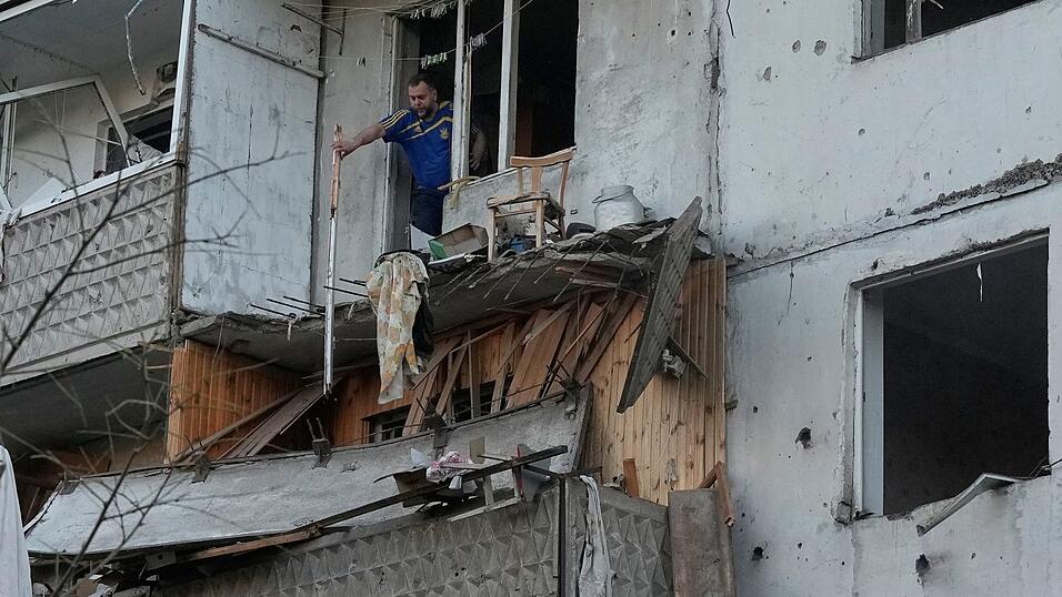Ein Mann räumt in Kiew Trümmer an seinem Wohnhaus raus, das nach einem russischen Raketeneinschlag beschädigt wurde. Ein Mann räumt in Kiew Trümmer an seinem Wohnhaus raus, das nach einem russischen Raketeneinschlag beschädigt wurde.