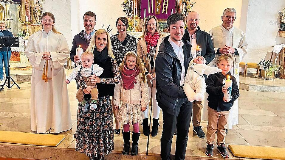 Die T&auml;uflinge Luis Tobias Moser (l.) und Maximilian Xaver Kuchler auf den Armen ihrer Paten, mit ihren Eltern, Cousine Amalie Moser, Bruder Paul, Ministrantin Romy und Pfarrer Johann Wutz