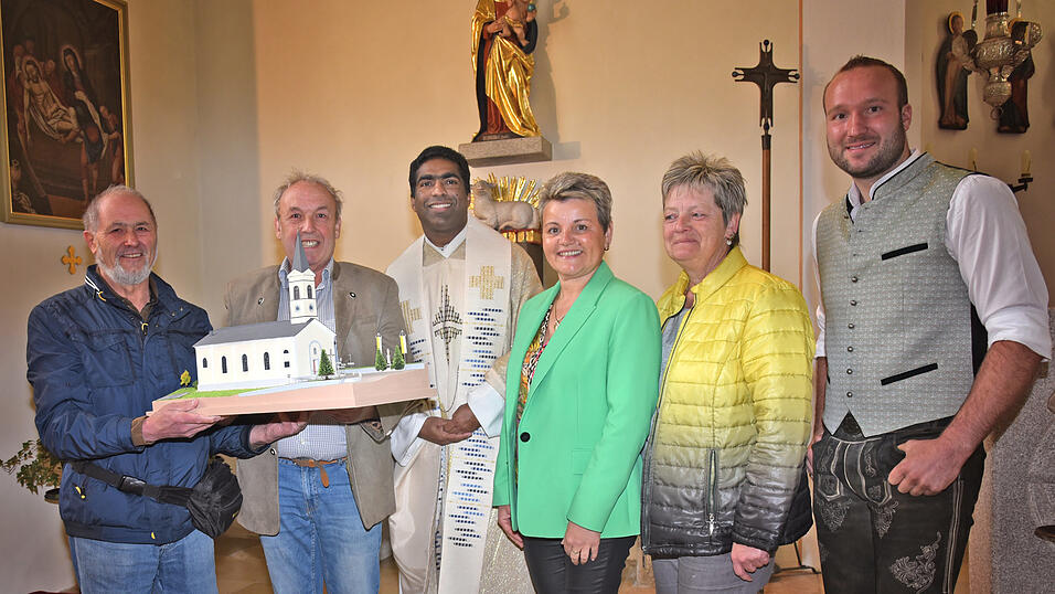 Bei der Übergabe: Modellbauer Friedrich Huber, Kirchenpfleger Ludwig Macht, Pfarrer Joseph Kokkoth, Pfarrgemeinderatsvorsitzende Monika Windmaißer mit Stellvertreterin Eva Fendl und Tobias Schötz von der Kirchenverwaltung freuen sich über das meisterhaft nachgebaute Kirchenmodell.