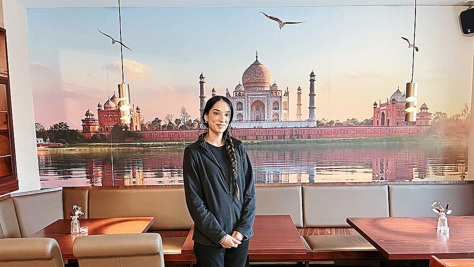 Ravinder Kaur Sahota, die Inhaberin des indischen Restaurants „Curry König“, vor einem Bild des Taj Mahals.