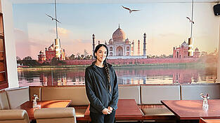 Ravinder Kaur Sahota, die Inhaberin des indischen Restaurants „Curry König“, vor einem Bild des Taj Mahals.