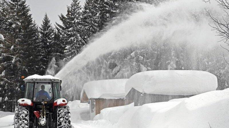 Ein Schneepflug räumt eine Straße in Ramsau am Dachstein. Österreich versinkt im Schnee. Ein Schneepflug räumt eine Straße in Ramsau am Dachstein. Österreich versinkt im Schnee.