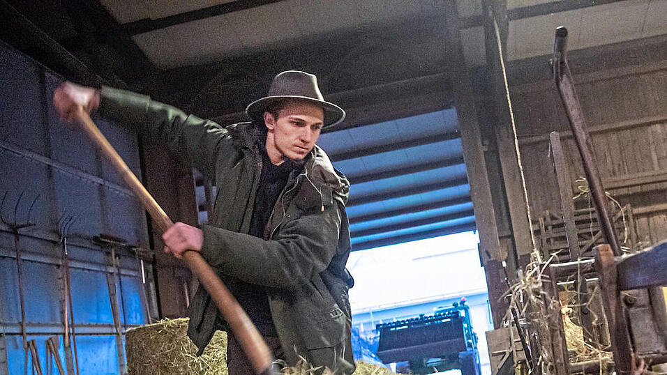 Der Schäfer versorgt in seinem Stall die Tiere mit Futter.