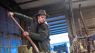 Der Schäfer versorgt in seinem Stall die Tiere mit Futter.