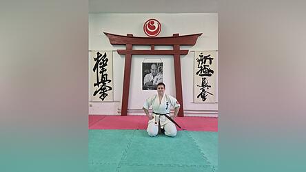 Diese Haltung ist Bestandteil der Anfangszeremonie. Hinter Andrea Adam ist Sosai Mas Oyama zu sehen - der Begr&uuml;nder von Kyokushin-Karate.