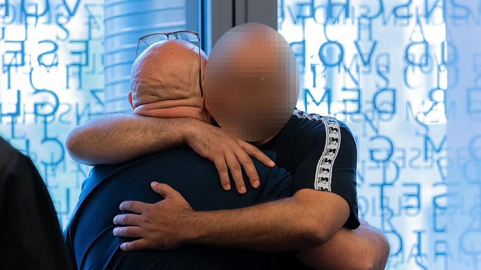 Der Hauptangeklagte (links) und ein Angeklagter umarmen sich in einem Gerichtssaal im Justizzentrum. (Archivbild) Der Hauptangeklagte (links) und ein Angeklagter umarmen sich in einem Gerichtssaal im Justizzentrum. (Archivbild)