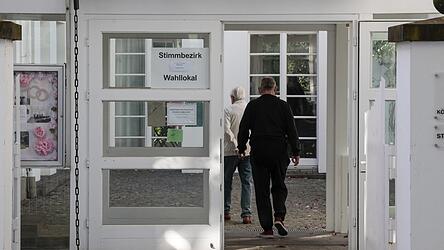 Wähler gehen in ein Wahllokal, um ihre Stimme zur Kommunalwahl abzugeben.
