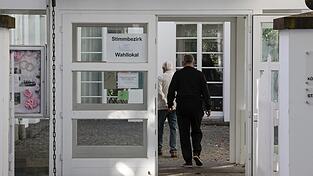 Wähler gehen in ein Wahllokal, um ihre Stimme zur Kommunalwahl abzugeben.