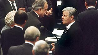 Der gestürzte Bundeskanzler Helmut Schmidt (r.) gratuliert seinem Nachfolger Helmut Kohl (M.) damals noch im Bonner Bundestag als erster.