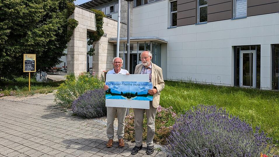 Der frühere stellvertretende Bürgermeister von Bad Abbach, Josef Geitner (l.), und sein Mitstreiter Jochen Wollenweber mit ihrem Protestplakat vor dem Eingang der Kaiser-Therme.