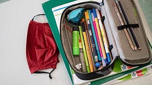 Eine Atemschutzmaske liegt neben einem Federm&auml;ppchen.