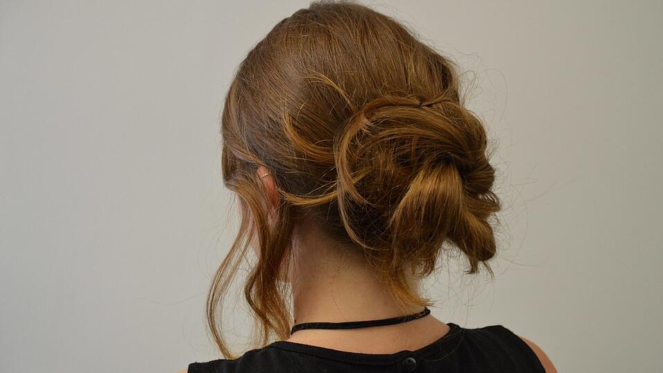 Schlage die hintere Partie locker ein und stecke Strähne für Strähne mit Haarnadeln fest. Schlage die hintere Partie locker ein und stecke Strähne für Strähne mit Haarnadeln fest.