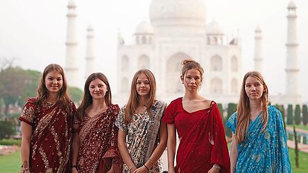 Daniela Vanic (2. v. r.) und Marie Wagner (2. v. l.) mit ihren Mitsch&uuml;lerinnen bei Sonnenaufgang in geliehenen Saris vor dem Taj Mahal.
