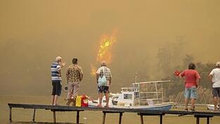 Touristen warten unweit von Bodrum darauf, in Sicherheit gebracht zu werden. Touristen warten unweit von Bodrum darauf, in Sicherheit gebracht zu werden.