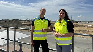 Alexander Kiy, Gesamtprojektleiter Werksaufbau, und Silvia Meyer, Leiterin der Abteilung Immobilienmanagement Hochvoltbatterie Niederbayern, berichteten am Dienstag vom Baufortschritt. Dazu zählen unter anderem die ersten Säulen der Montagehalle (hinten links).