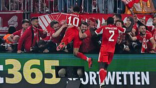 Nach dem letzten Bayern-Tor gegen Real springen einige M&uuml;nchner Fans und Bayern-Profi Jamal Musiala im Jubel den anwesenden Fotografen in den R&uuml;cken.