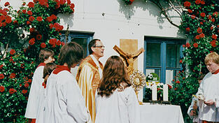 Ein Foto aus der Sammlung der Seebauers: Pater Dominik vor dem selbst gebauten Altar und der Rosenranke.