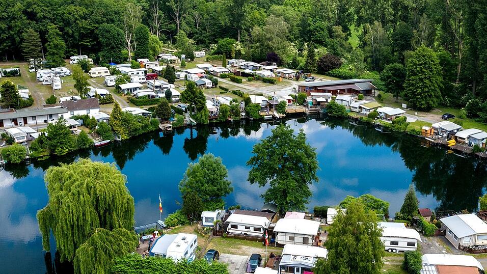 Wohnwagen auf einem Campingplatz an einem See. Manche Menschen lieben so einen Urlaub. Andere nicht. Wohnwagen auf einem Campingplatz an einem See. Manche Menschen lieben so einen Urlaub. Andere nicht.