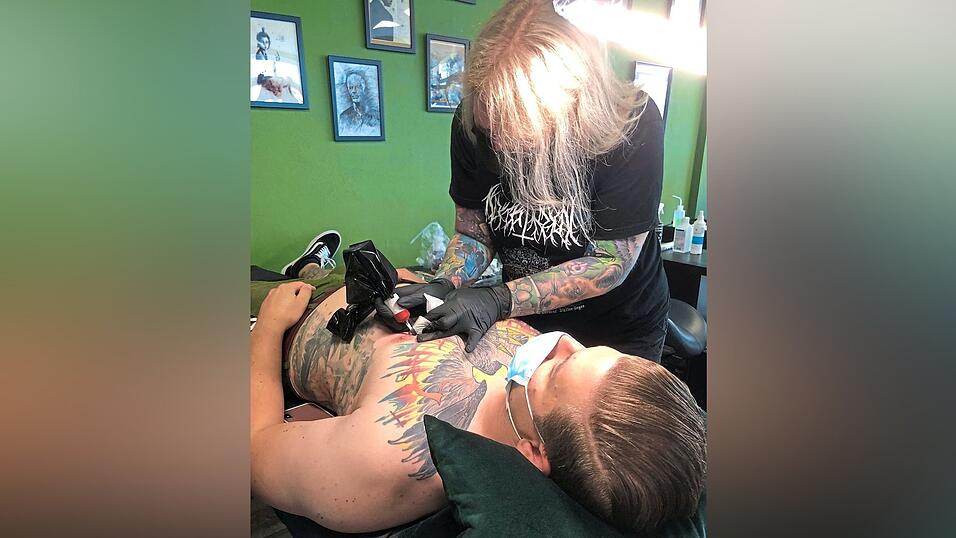 Oliver lässt die blauen Pfeilspitzen seines Brusttattoos von der Kollegin schwarz überstechen. Oliver lässt die blauen Pfeilspitzen seines Brusttattoos von der Kollegin schwarz überstechen.