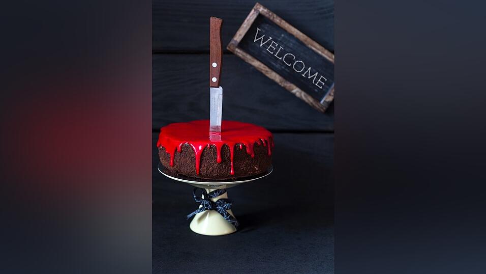 Diese Torte blutet. Wer hat sie erstochen? Das Messer steckt noch im Herzen des Gebäcks. Mit ganz einfachen Mitteln lässt sich dieser Hingucker arrangieren. Zentrale Elemente sind Messer, rote Lebensmittelfarbe und eine köstliche Torte. Das Rezept ist aber eher nichts für die Kinder-Halloween-Party!