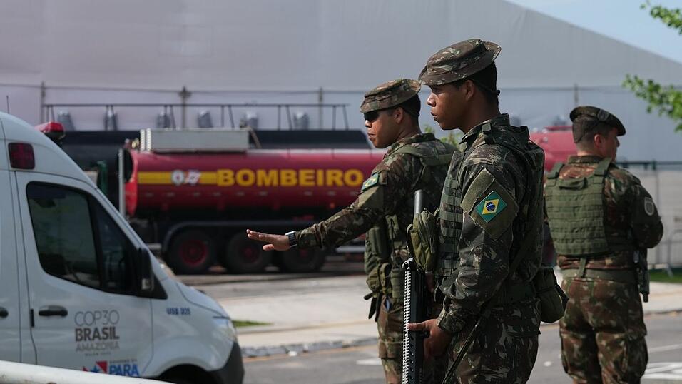 Sicherheitskräfte leiten Fahrzeuge nach einem Brand auf dem Gelände der Weltklimakonferenz. Sicherheitskräfte leiten Fahrzeuge nach einem Brand auf dem Gelände der Weltklimakonferenz.