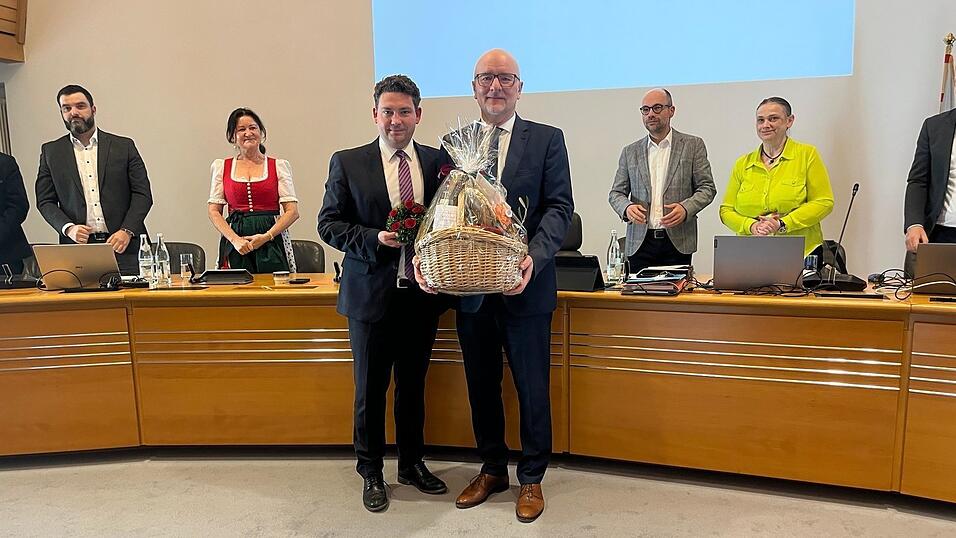 Im Namen des Gremiums &uuml;berreichte zweiter B&uuml;rgermeister Thomas Haslinger (CSU, vorne links) dem scheidenden Oberb&uuml;rgermeister Alexander Putz (CSU) einen Geschenkekorb und ein Buchskranzl.