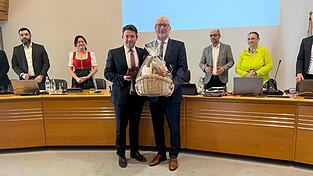 Im Namen des Gremiums &uuml;berreichte zweiter B&uuml;rgermeister Thomas Haslinger (CSU, vorne links) dem scheidenden Oberb&uuml;rgermeister Alexander Putz (CSU) einen Geschenkekorb und ein Buchskranzl.