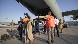Schutzbedürftige Menschen betreten 2021 im Rahmen der Evakuierungen von Ortskräften in Taschkent (Usbekistan) kurz nach dem Flug aus Kabul sicheren Boden zum Weiterflug nach Deutschland (Archiv).