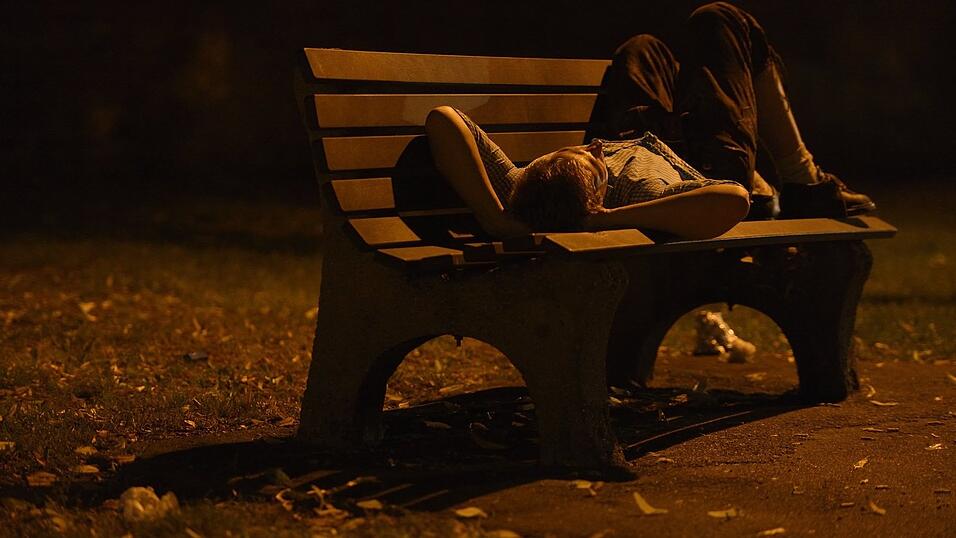 Ein Betrunkener schläft nach einem wohl anstrengenden Volksfest-Tag auf einer Parkpank. Ein Betrunkener schläft nach einem wohl anstrengenden Volksfest-Tag auf einer Parkpank.