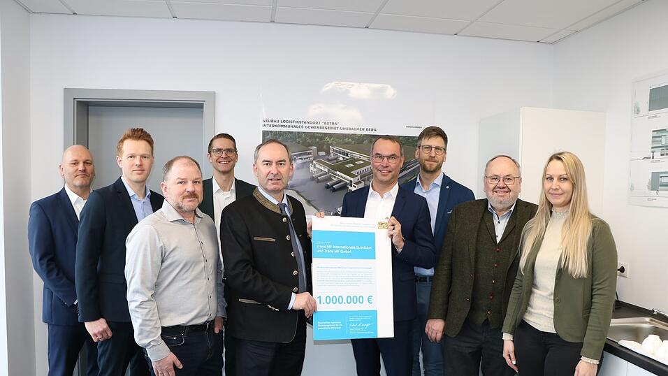 Wirtschaftsminister Hubert Aiwanger &uuml;bergibt den F&ouml;rderbescheid an Bernhard Muggenthaler von Trans MF. Mit dabei (v. l. ) Gerald Tausenteufel (Sparkasse), Michael Luschmann (Regierung Niederbayern), Florian Bindhammer (Architekt), Christian Gallwitz (Sparkasse), Minister Hubert Aiwanger, Gesch&auml;ftsf&uuml;hrer Bernhard Muggenthaler, Tobias Zacher (Prokurist Trans MF) B&uuml;rgermeister Ludwig Robold (Ergoldsbach) und Sandra Wittmann (Bauamt Ergoldsbach).
