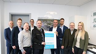 Wirtschaftsminister Hubert Aiwanger &uuml;bergibt den F&ouml;rderbescheid an Bernhard Muggenthaler von Trans MF. Mit dabei (v. l. ) Gerald Tausenteufel (Sparkasse), Michael Luschmann (Regierung Niederbayern), Florian Bindhammer (Architekt), Christian Gallwitz (Sparkasse), Minister Hubert Aiwanger, Gesch&auml;ftsf&uuml;hrer Bernhard Muggenthaler, Tobias Zacher (Prokurist Trans MF) B&uuml;rgermeister Ludwig Robold (Ergoldsbach) und Sandra Wittmann (Bauamt Ergoldsbach).