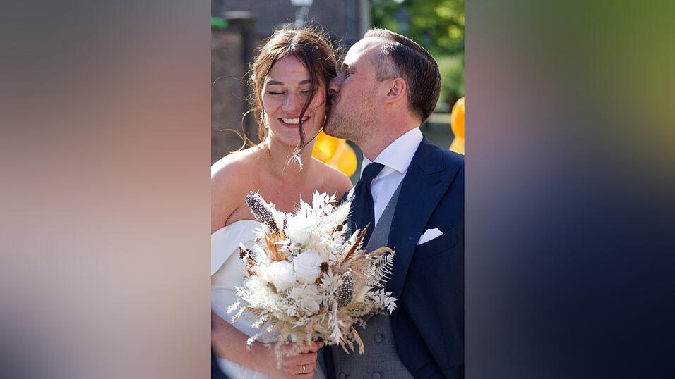 Nach der Hochzeit küsst Joe Laschet vor der Kirche seine Frau Andrea