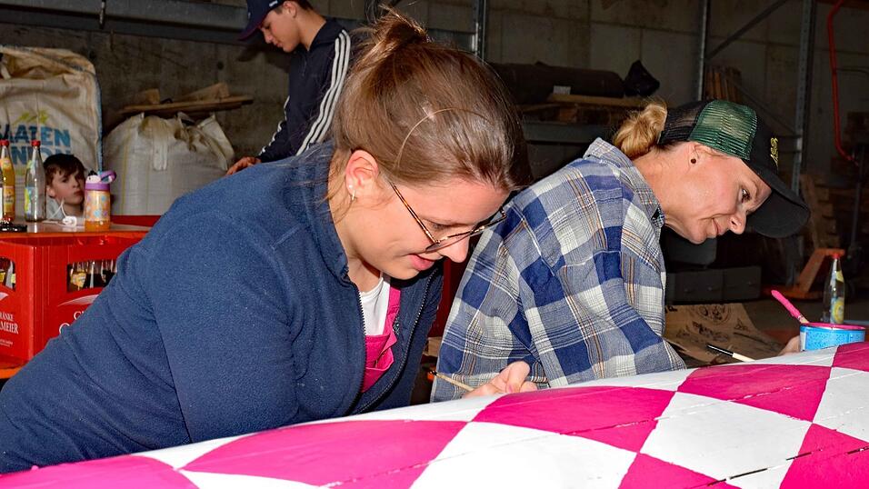 Festbraut Ayla Schmidt (l.) und Festmutter Marion Peis (r.) beim Anmalen des Baumes in pink.
