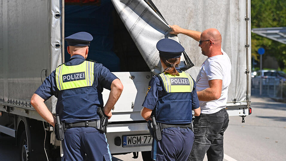 Das klassische Bild der Grenzpolizei: Beamte kontrollieren die Ladefläche eines Lastwagens.